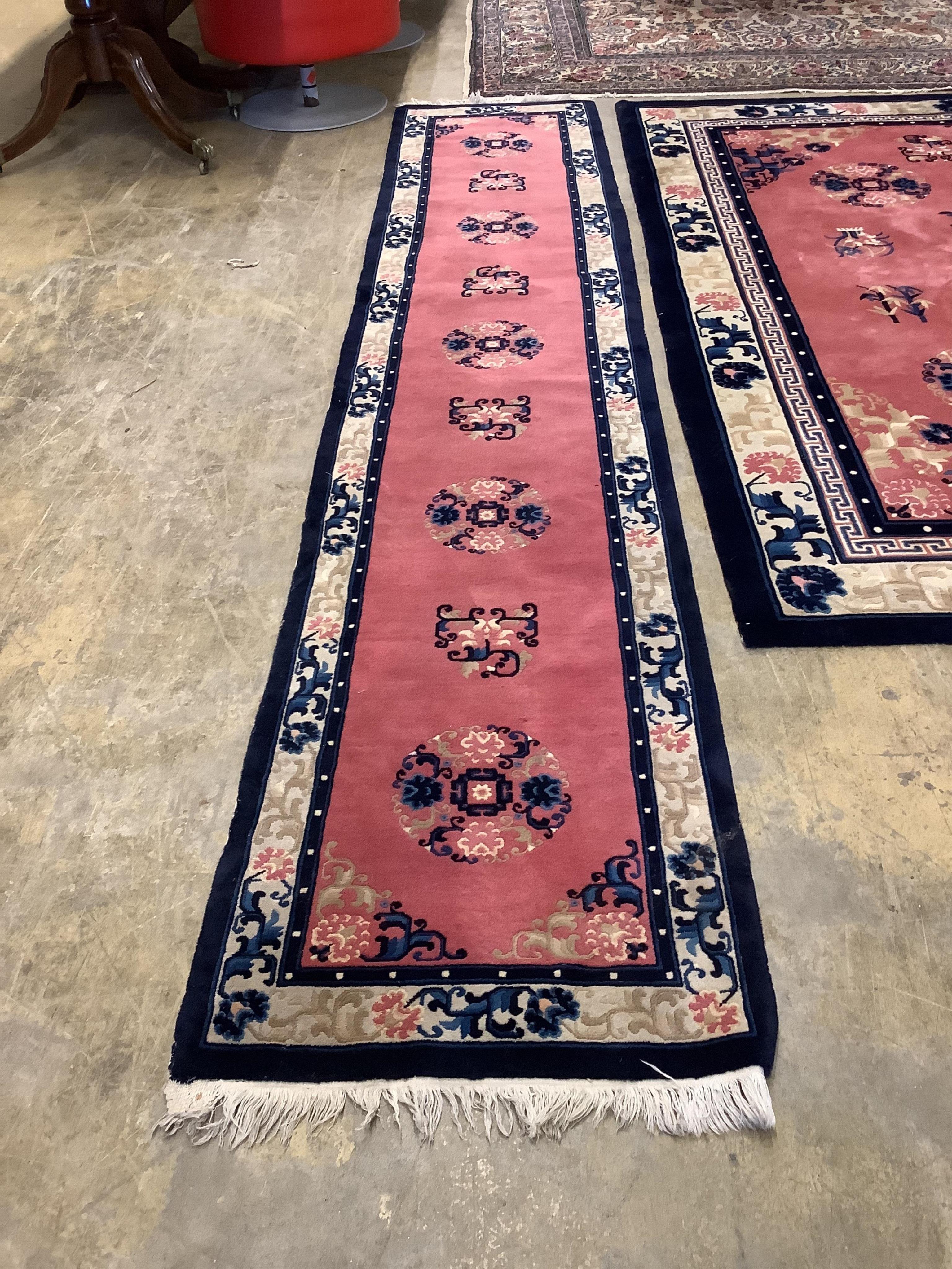 A Chinese pink ground carpet, approx. 274 x 183cm, and a similar runner, approx. 75 x 351cm (2). Condition - fair to good